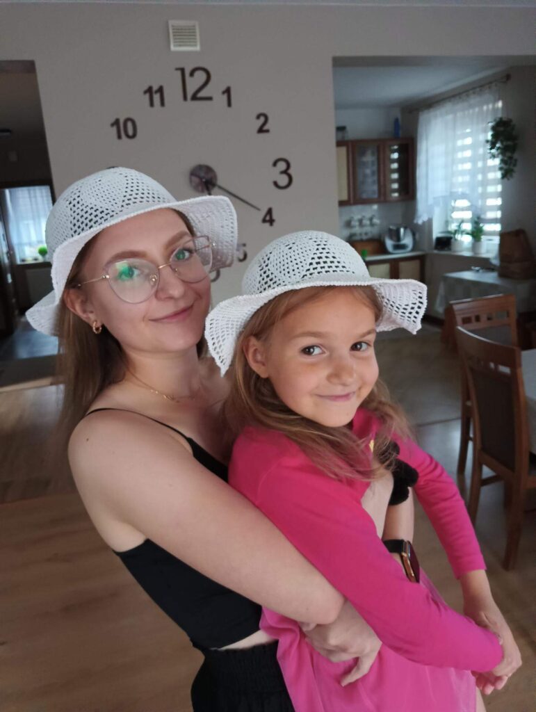 Dwie modelki: mama i córcia w kapeluszach zrobionych ręcznie na szydełku z kordonka w kolorze białym.