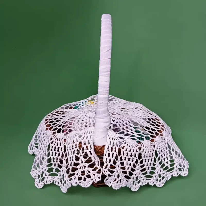 Szydełkowa serwetka zakrywajaca koszyczek wielkanocny zrobiona z białego kordonka
