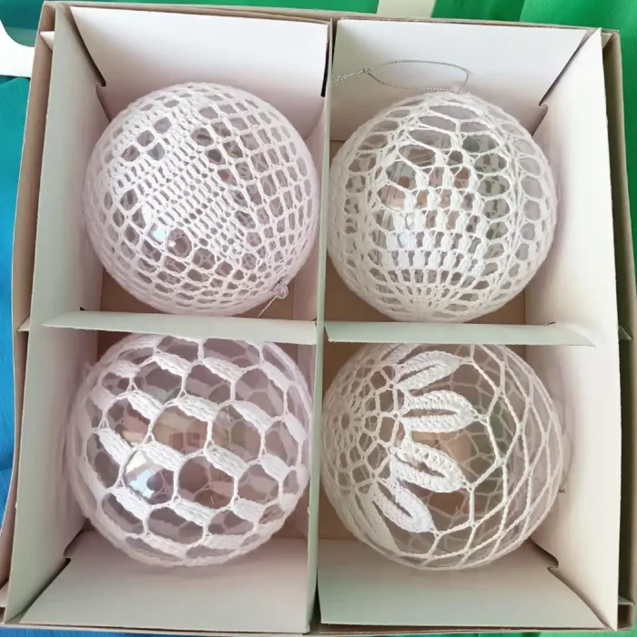 Komplet białych bombek szydełkowych w otwartym pudelku