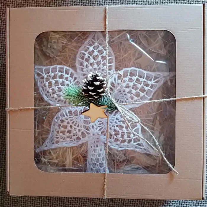 Gwiazda na czubek choinki zrobiona na szydełku zapakowana jak na prezent w pudełko z okienkiem