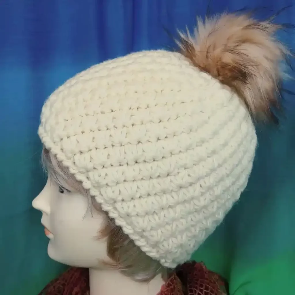 Ciepła czapka damska handmade zrobiona na szydełku wzorem gwiazdkowym, prezentowana na głowie manekina damskiego