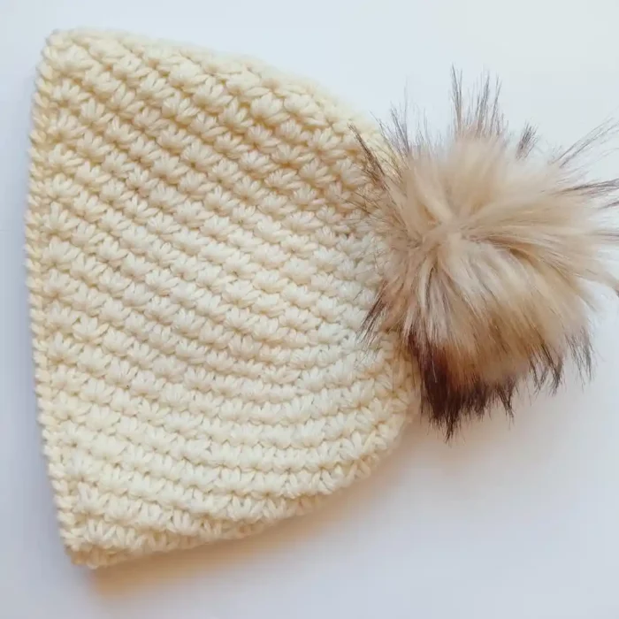 Ciepła czapka damska handmade zrobiona na szydełku wzorem gwiazdkowym, rozłożona na płasko.