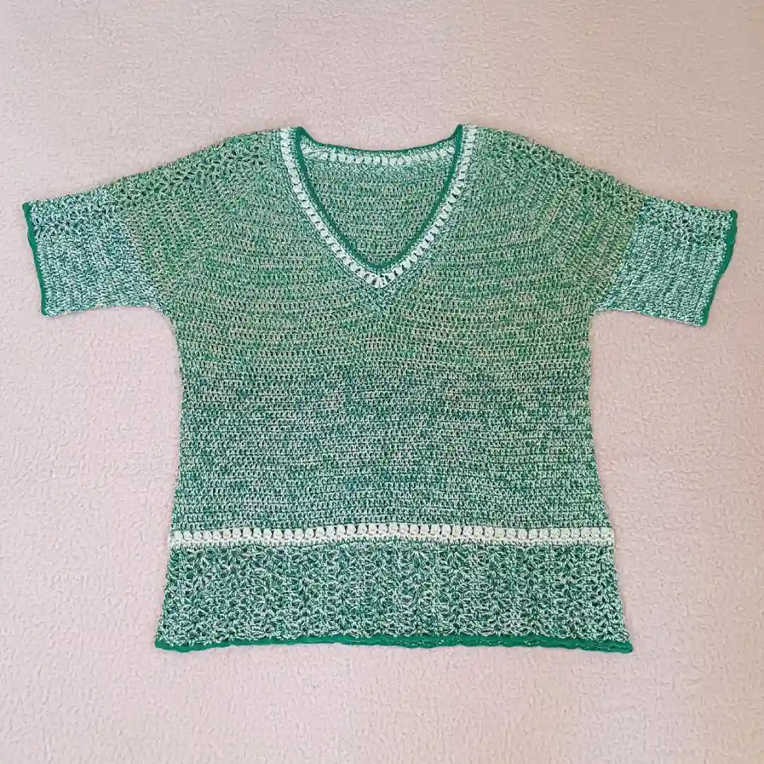 Bluzka zrobiona na szydełku z melanżowej beżowo-zielonej włóczki bawełnianej.