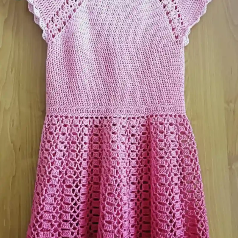 Sukienka dla dziewczynki zrobiona na szydełku_2 Szydełkowa różowa sukienka dla dziewczynki zawieszona na wieszaku