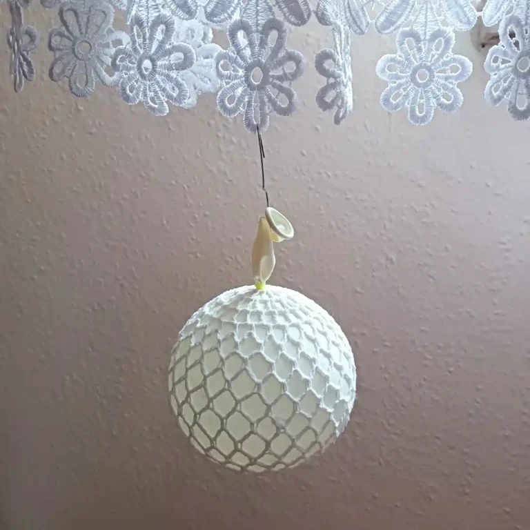 Bombka na balonie zawieszona na firance zdjęcie poglądowe do artykułu Jak usztywniać i suszyć robótki szydełkowe