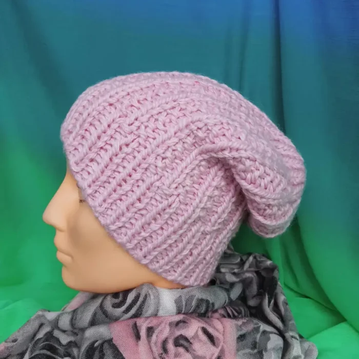 Zdjęcie podladowe do artykułu: Jaką włóczkę wybrać na czapkę i szalik ?Luksusowa wełniana czapka damska handmade w kolorze pastelowego różu prezentowana na głowie manekin