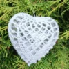Serduszko na wypełnieniu akrylowym 8 cm z perełkami_5 Szydełkowe serce 8 cm zrobione z białego kordonka, z perelkami, na tle zielonego iglastego krzewu