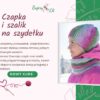 Grafika promocyjna kursu szydełkowania "Bajery Eli". Przedstawia kobietę w kolorowym, falowanym komplecie: czapce i szaliku-kominie. Po lewej stronie tekst zapraszający na "Nowy Kurs" pod tytułem "Czapka i szalik na szydełku". Tło jasnoróżowe z zielonymi elementami roślinnymi.
